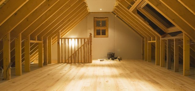 Finished loft conversion with exposed beams and wooden flooring